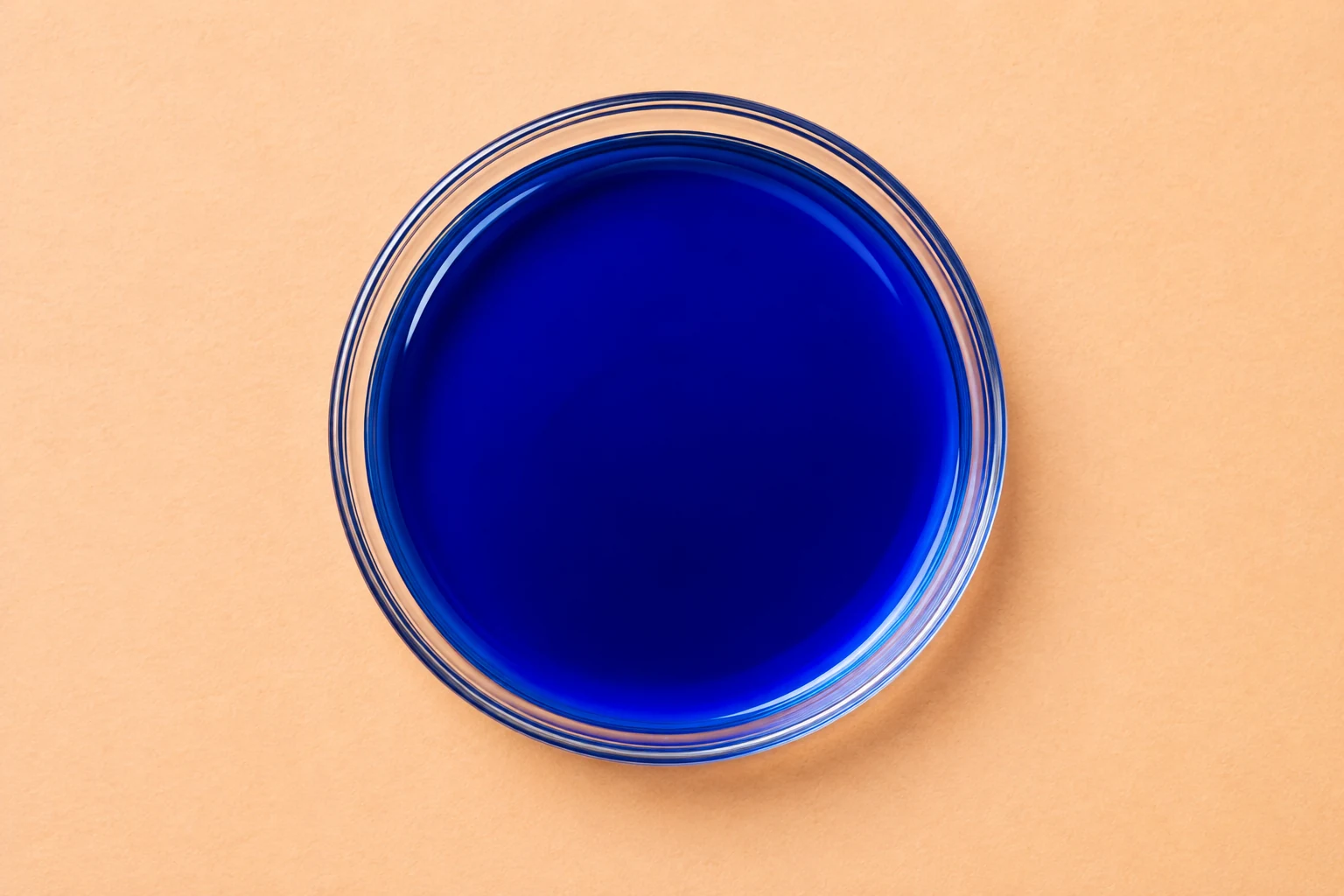 Vivid blue liquid in a clear glass dish