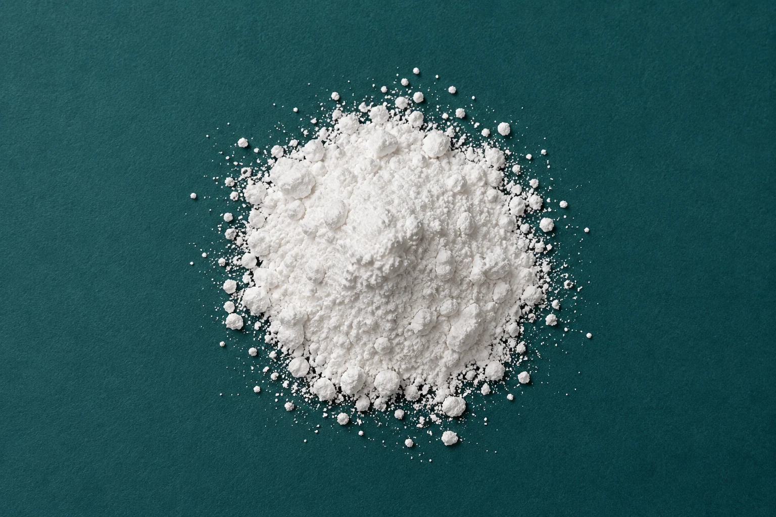 Fine white zinc powder on a deep teal surface
